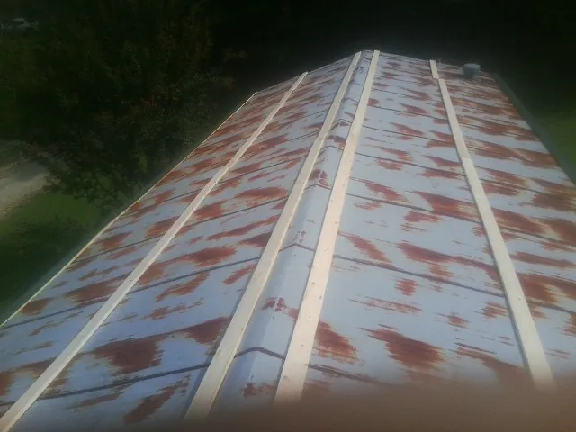 Rusted metal roof panels with new wood purlins before replacement — Storm Damage Roof Repair in Elrama by Roofing Brothers