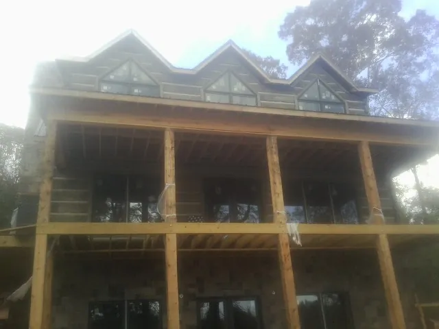Dormers and porch framing on a large log home under construction — Roof Coating work by our crew in Elrama