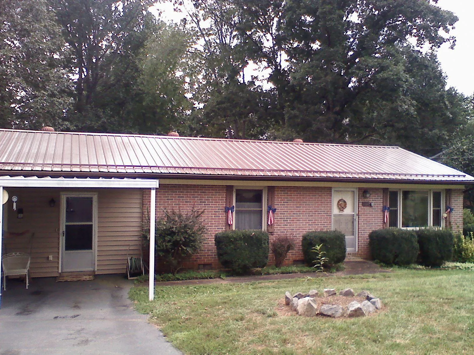 Bronze metal roof and carport on a brick ranch home — Roof Repair work by our crew in Elrama